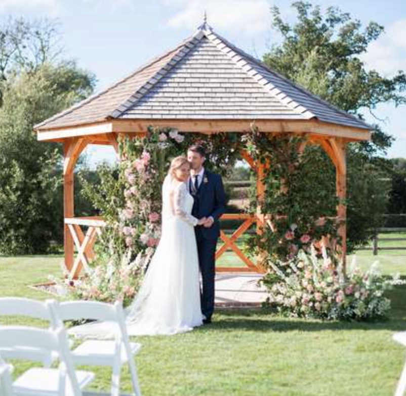 bride and groom in front of the wedding pavilion