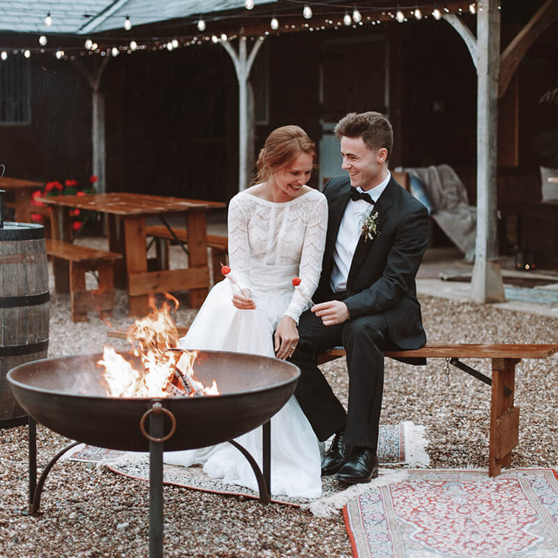 bride and groom toasting marshmallows at the fire pit