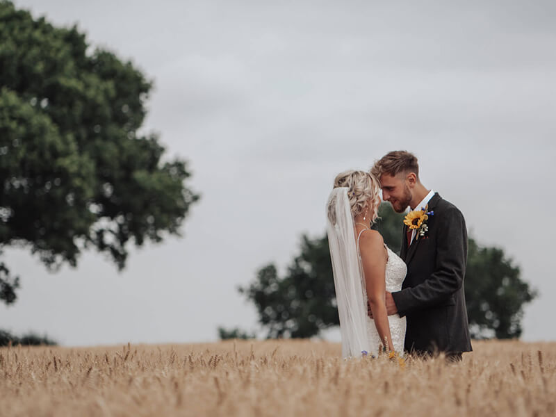 bride and groom in a field of wheat