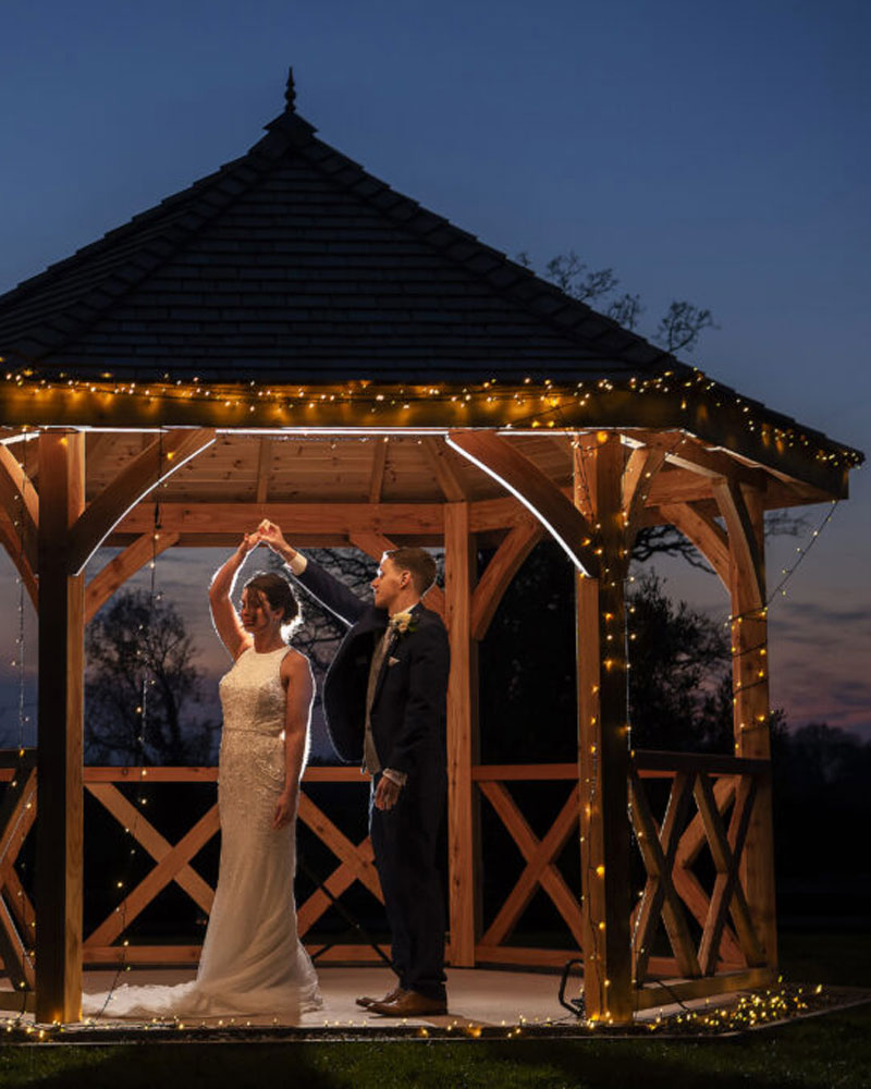 bride and groom in the pavilion with fairy lights
