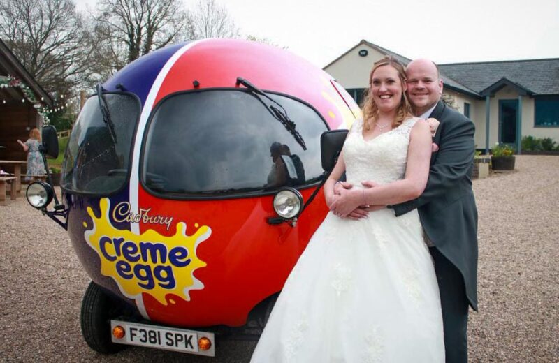 Married Couple stood next to Cadbury Creme Egg Car