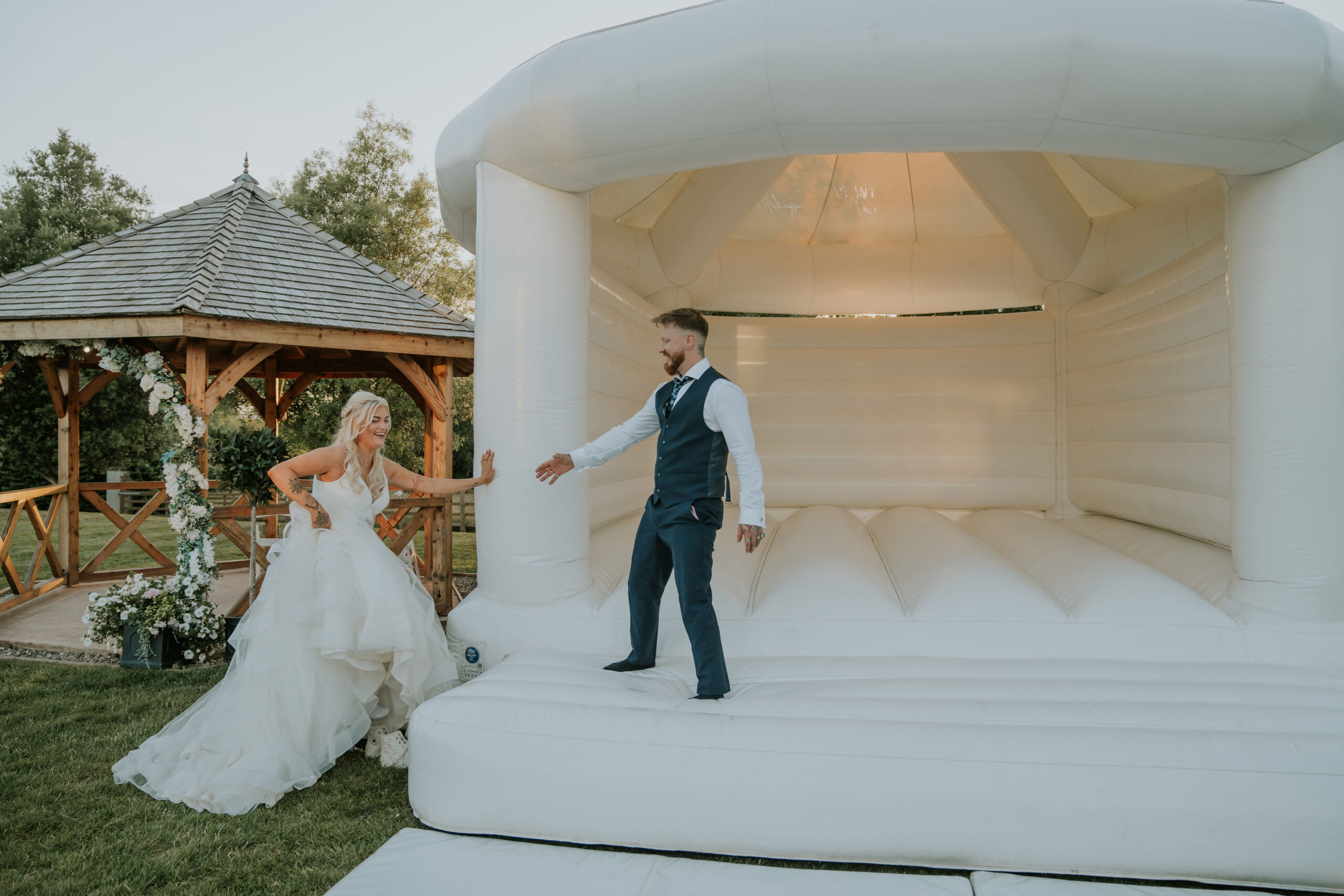 Bride and groom on white bouncy castle