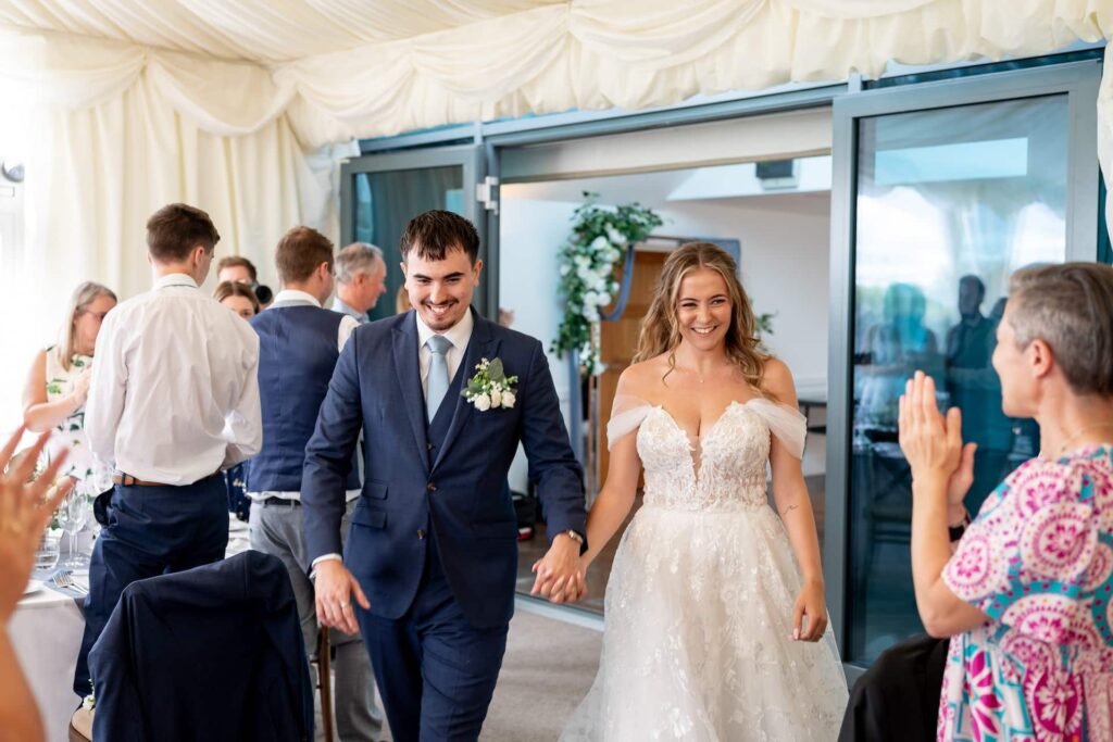 Bride and groom entering the marquee for wedding breakfast